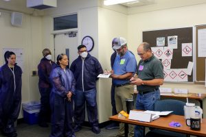 Students from the HAZWOPER and Asbestos Contractor Supervisor courses wearing PPE in the classroom while doing a simulated exercise.